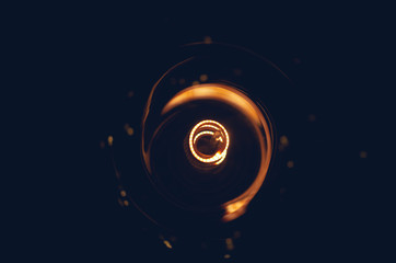 Fototapeta na wymiar Abstract dark background of a glowing filament light bulb.