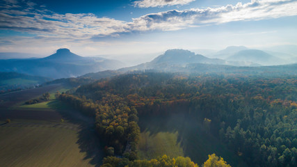 Fototapeta na wymiar Konigstein Fortress - a Saxon mountain fortress near the town of Konigstein, located on a plateau rising 247 meters above the Elbe level, bathed in fog, aerial view