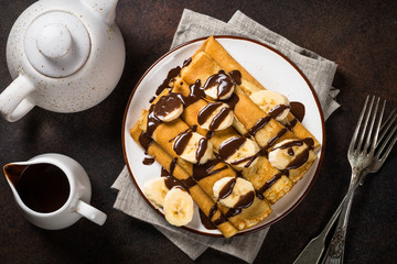 Crepes with chocolate and banana top view.
