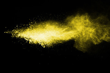 Yellow powder explosion on black background.