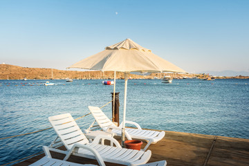 Sunbeds and  umbrellas on a beach at sunset, Aegean sea, Turkey