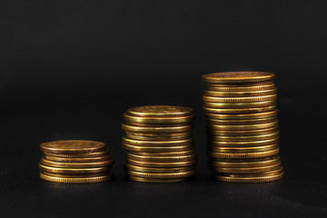 three stacks of coins on black leather