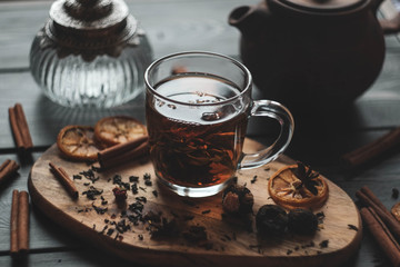 flower tea in a transparent mug with welding and spices/ vintage bottle and clay teapot