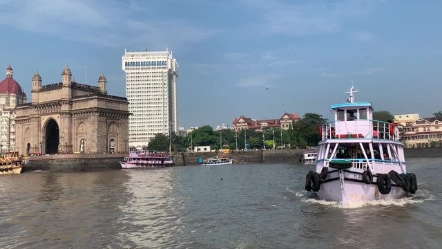 Ferry boat leaving the Apollo Bunder, Colaba port with Gateway of India and Taj Mahal Palace Hotel Mumbai in the background