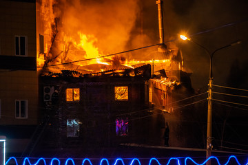 firefighters extinguish burning house in the dark, Burning building in Samara, Russia