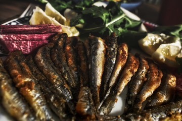 fresh fish and dinner roast anchovy platter, on wooden table.
