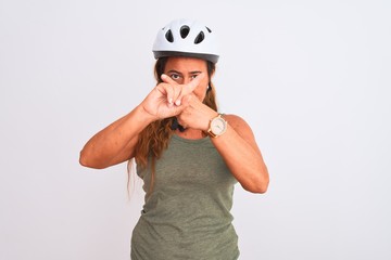 Middle age mature cyclist woman wearing safety helmet over isolated background Rejection expression crossing fingers doing negative sign