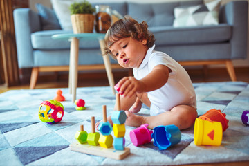 Beautiful toddler child girl playing with toys on the carpet