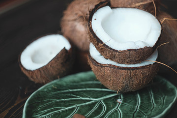 coconuts on a dark table and green leaf shaped plate\ small field of depth