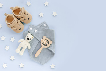 Set of baby shoes, toys and accessories on blue background. Fashion newborn stuff. Flat lay, top view