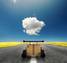 Priority Cardboard box with racing wheels like a car. Fast shipping by road.