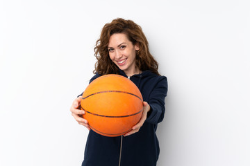 Young pretty woman over isolated background with ball of basketball