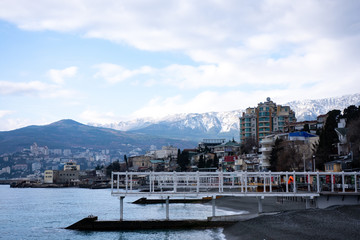 Beautiful seascape with views of the snow-capped mountains and the pier going to the sea