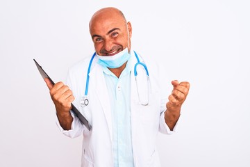 Doctor man wearing stethoscope and mask holding clipboard over isolated white background screaming proud and celebrating victory and success very excited, cheering emotion