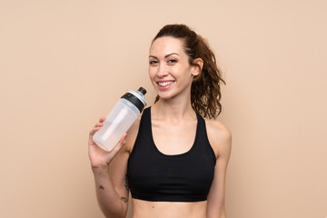 Young sport woman over isolated background with sports water bottle