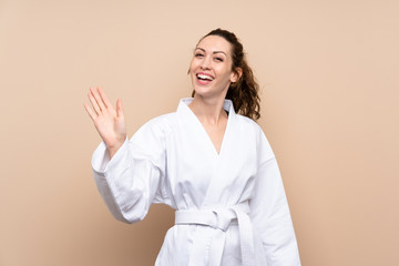 Young woman doing karate saluting with hand with happy expression