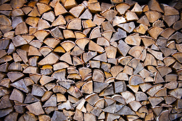 Pile of wood logs ready for winter - landscape exterior. tree stumps texture. Wooden background - natural brown texture