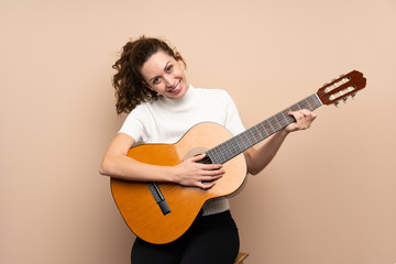 Fototapeta premium Young woman with guitar over isolated background