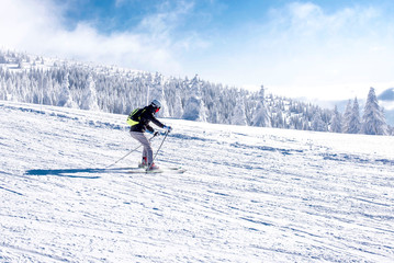 Winter sport concept, skier enjoys skiing in high mountains with beautiful winter landscape in the...