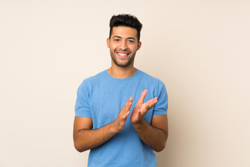 Young handsome man over isolated background applauding after presentation in a conference