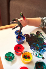 Obraz premium Hands of a child who paints with bright finger paints