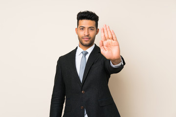 Young handsome businessman man over isolated background making stop gesture with her hand