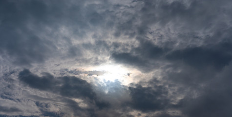 The sky with clouds through which the sun shines