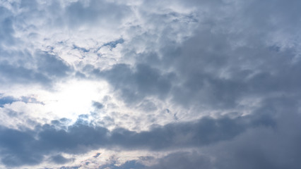 The sky with clouds through which the sun shines
