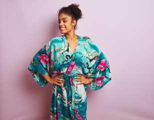 Fototapeta premium Young beautiful african american woman standing wearing elegant colorful caftan