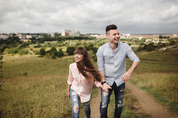 Fototapeta premium Young fun romantic couple is having fun around the city in summer sunny day. Enjoying spending time together in holiday. Valentine's Day.