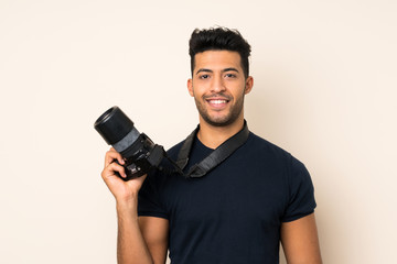 Fototapeta na wymiar Young handsome man over isolated background with a professional camera