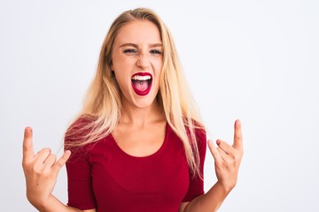 Young beautiful woman wearing red t-shirt standing over isolated white background shouting with crazy expression doing rock symbol with hands up. Music star. Heavy concept.