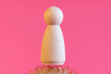 Fototapeta na wymiar Figurine of a women on the needles of a cactus. Concept of pain. The concept of menstrual pain in women. Acute pain concept. copy space