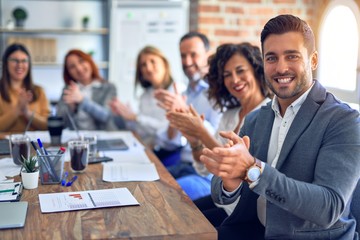 Group of business workers smiling happy and confident. Working together with smile on face looking at the camera applauding at the office