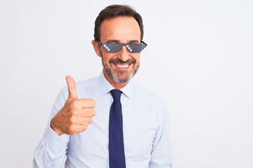 Middle age businessman wearing thug life sunglasses over isolated white background doing happy thumbs up gesture with hand. Approving expression looking at the camera with showing success.