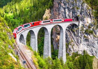 Bernina Express train on Landwasser Viaduct, Switzerland. Aerial scenic view of famous railway in Swiss Alps.