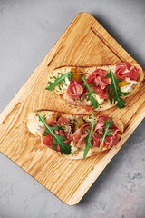 bruschetta with gorgonzola cheese, smoked meat, arugula