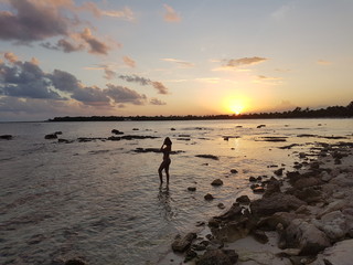 A young woman (girl)  is standing on the beach in Cancun, Mexico during the sunset