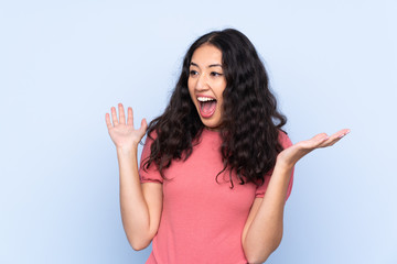 Fototapeta premium Mixed race woman wearing a sweater over isolated blue background with surprise facial expression