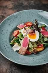 warm salad with beef, tomatoes and egg on top