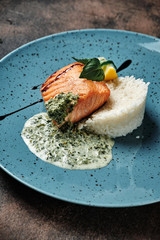 risotto with salmon and sauce on a blue plate