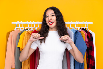 Mixed race woman in a clothing store proud and self-satisfied