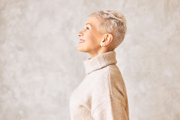 Mature age, style and fashion concept. Side view of attractive fashionable European female...