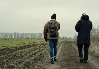 young man and woman walking on country road