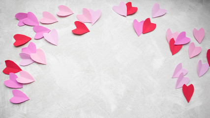 Valentines day background. Multicolored pastel red pink purple lilac hearts on a light texture background. Copy space.