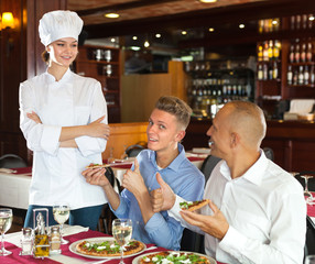 Delighted guests lauding female chef