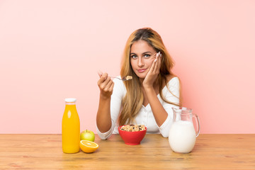 Young blonde woman having breakfast milk