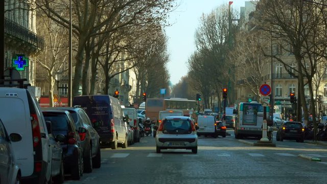 Traffic at the European city street. Cars and bus are stopping at a crossroad on a red stop sign