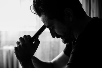 Man holding a TV remote and leaning his head