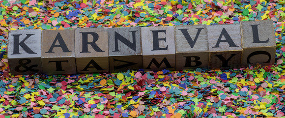"Karneval" written on wooden blocks isolated on confetti background